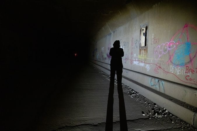 Shadow of person in grafitti tunnel