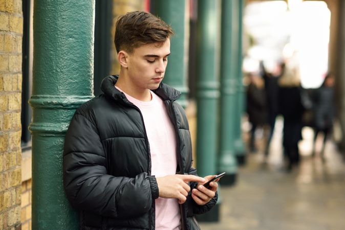 Man looking down and texting in London street