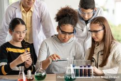 Multi-ethnic students and teacher in science class doing experiment 5RQoJ0