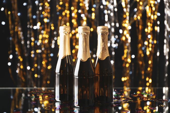 Mini champagne bottles on blurred background, space for text