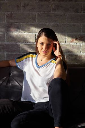 Young woman sitting on couch in living room