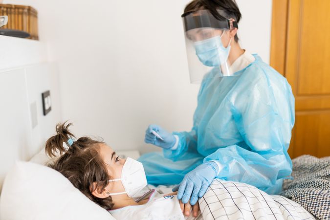 Female in full PPE checking on sick child