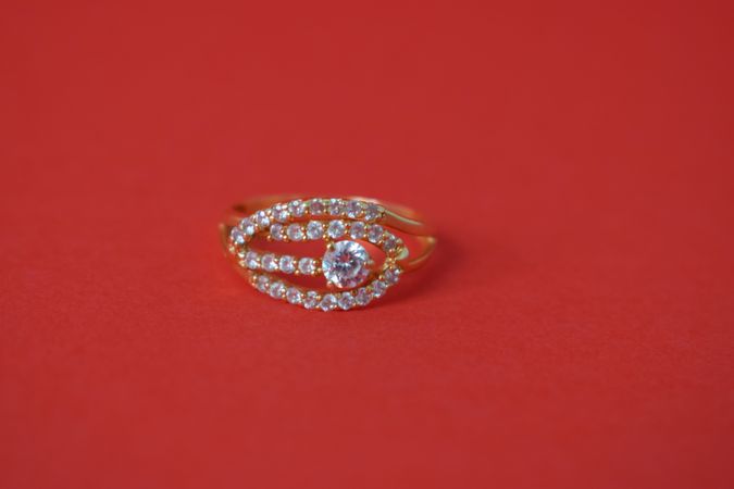 Woman's diamond ring on red background