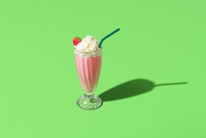 Milkshake glass minimalist on a green background