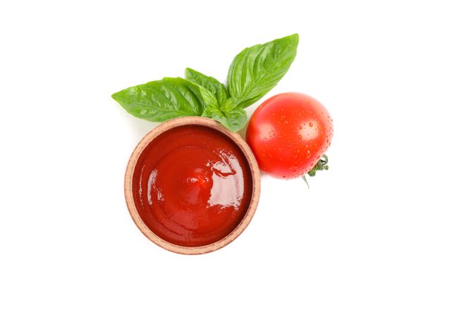 Fresh cherry tomato with basil and sauce isolated on plain background, top view. Ripe vegetables