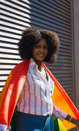 Black woman posing happily with the LGBT flag