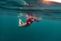 Woman diving in blue waving water