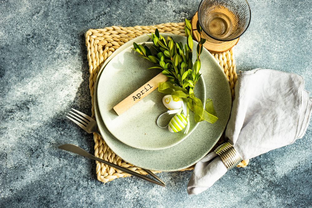 Easter concept with branch and green decorative eggs on ceramic plates