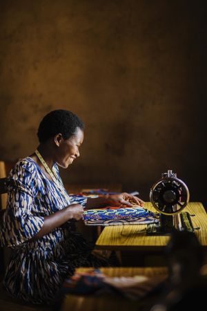 Smiling woman sitting beside sewing machine