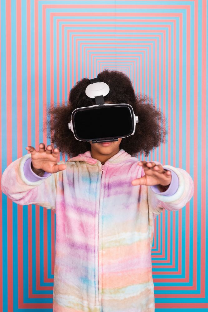 Black girl using VR goggles in studio