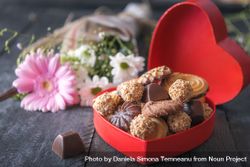 Delicious sweets in a red box and flowers on rustic table 5zp3Pb