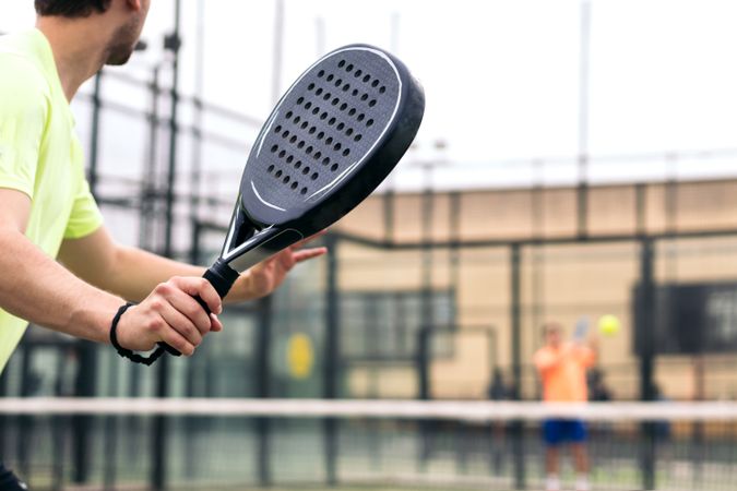Back view of a man playing paddle tennis