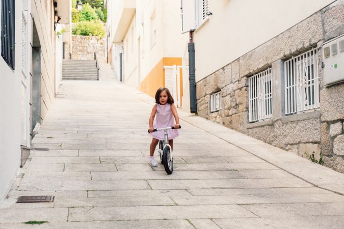 Girl riding on bicycle in narrow street