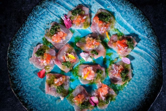 Plate with delicious fish dish on marble surface