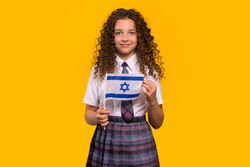 Girl in school uniform holding Israeli flag