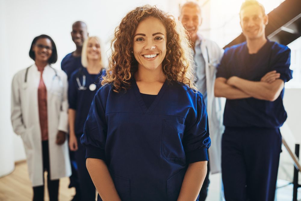 Smiling doctor with staff behind her