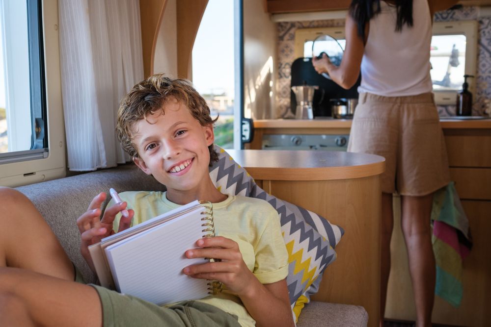 Positive boy with pen and notebook in RV