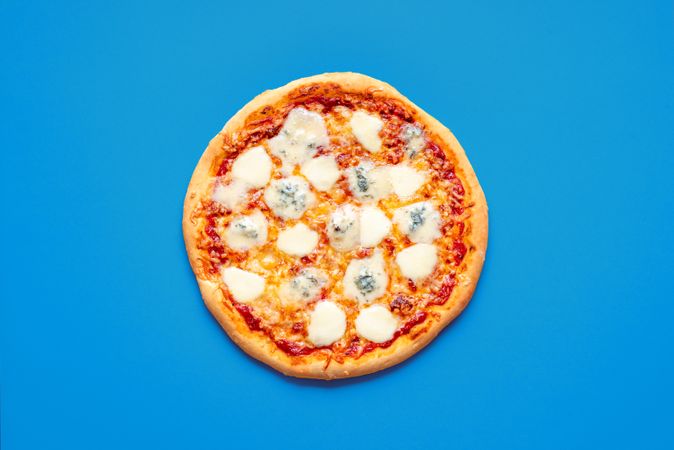 Homemade cheese pizza minimalist on a blue background