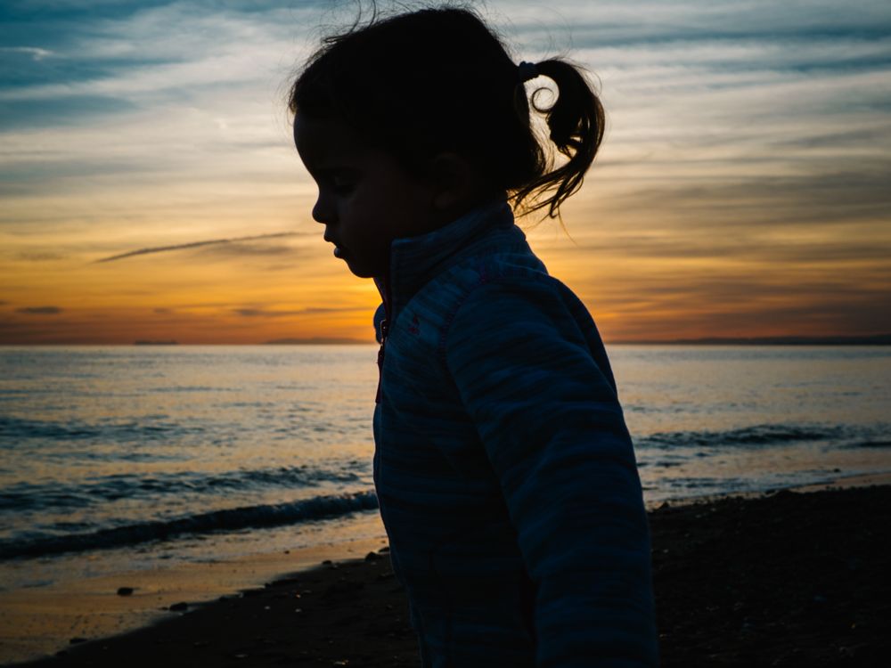 little girl silhouette at beach sunset