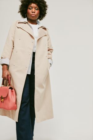 Woman standing in camel trench coat