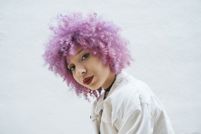 Stylish woman with pink hair looking at camera