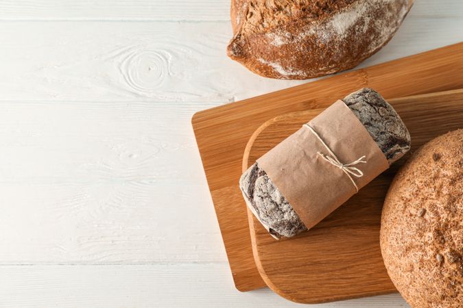 Bakery products and cutting boards on wooden background, top view and space for text