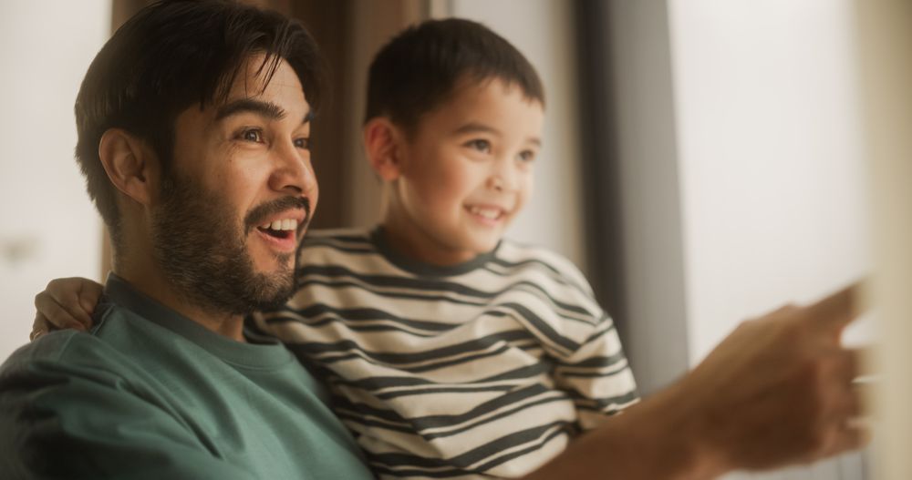 Portrait of Fatherly Love: A Young Father Holding His Male Child in His Arms as He Plays and Caresses Him.
