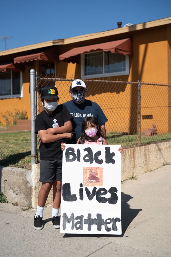 Los Angeles, CA, USA — June 7th, 2020: father and two children stand on sidewalk with protest sign