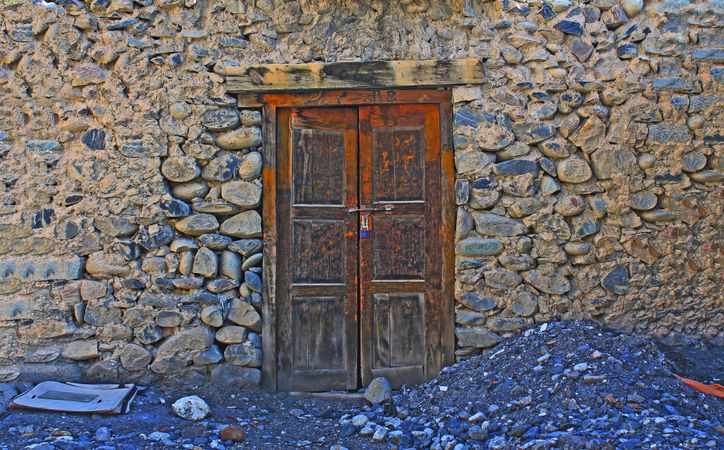 Wooden door in stone wall with blue undertones