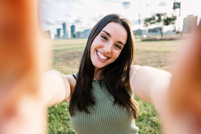 POV of brunette woman taking selfie in field