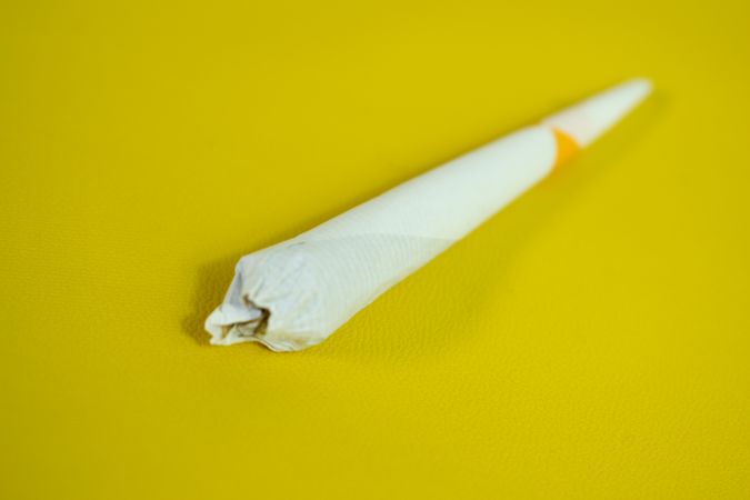 Rolled cigarette on yellow table