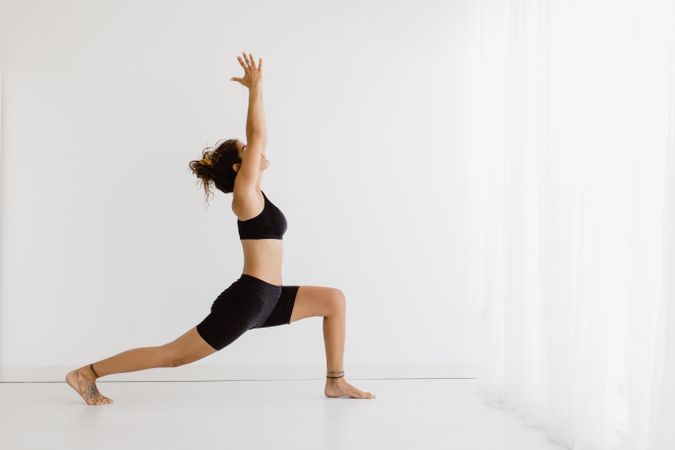 Sportive woman performing yoga pose in room