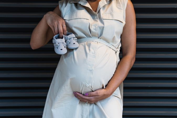 Anonymous Black woman showing baby booties