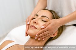 Woman having her face massaged by therapist 4AqE84