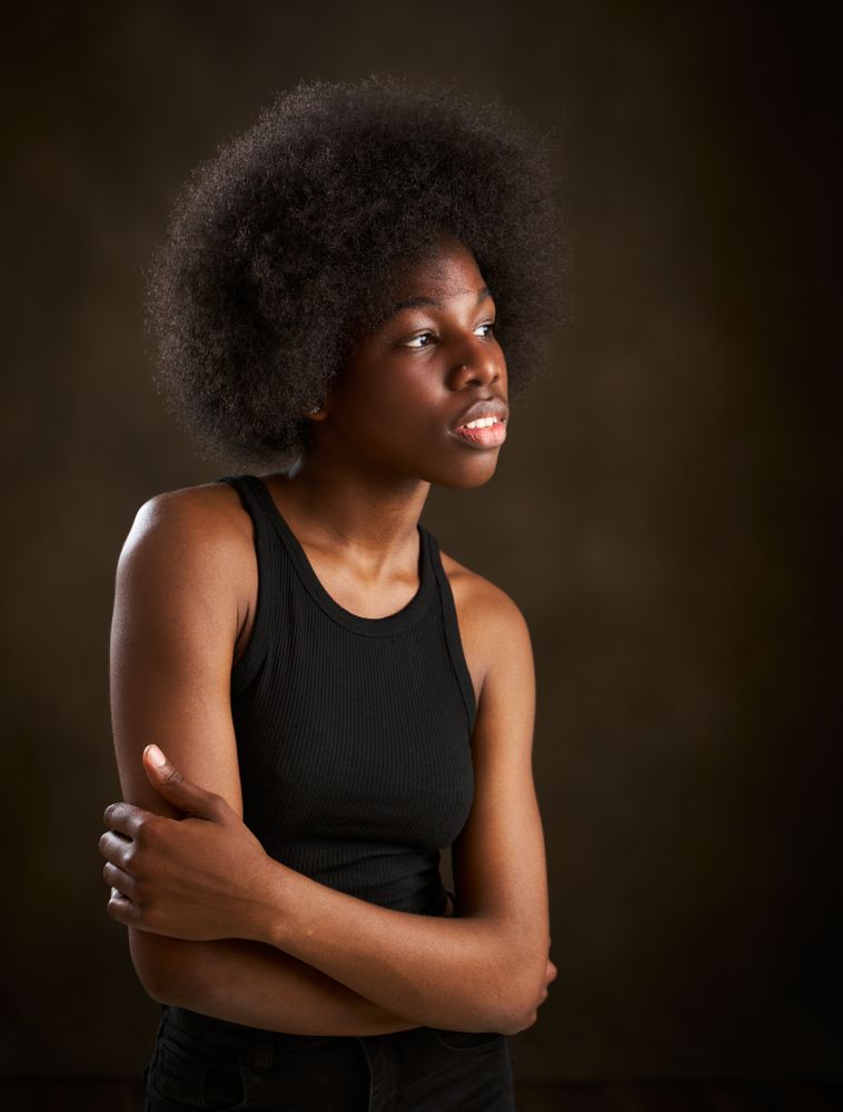 Young Black woman with afro hairstyle seen from the side