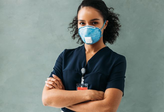 Confident female medical professional in protective mask with arms crossed