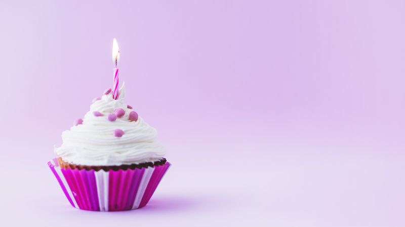 Purple birthday cupcake with candle and copy space