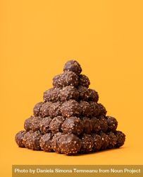 Chocolate truffle pyramid on an orange background 0P7GNb