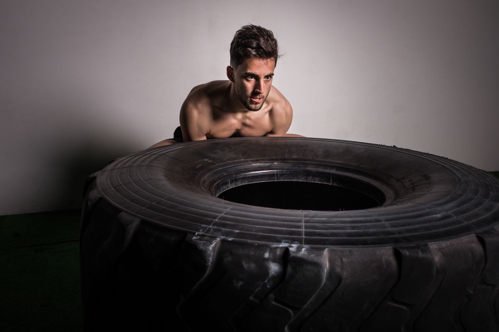 Man flipping big tires in gym