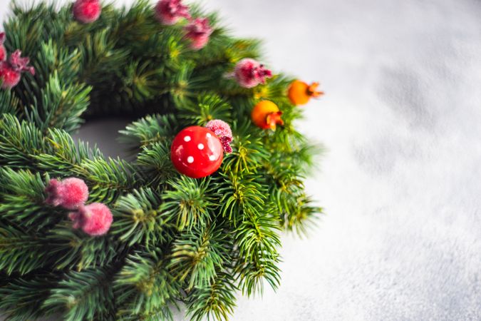 Close up of Christmas wreath with red berries on marble counter