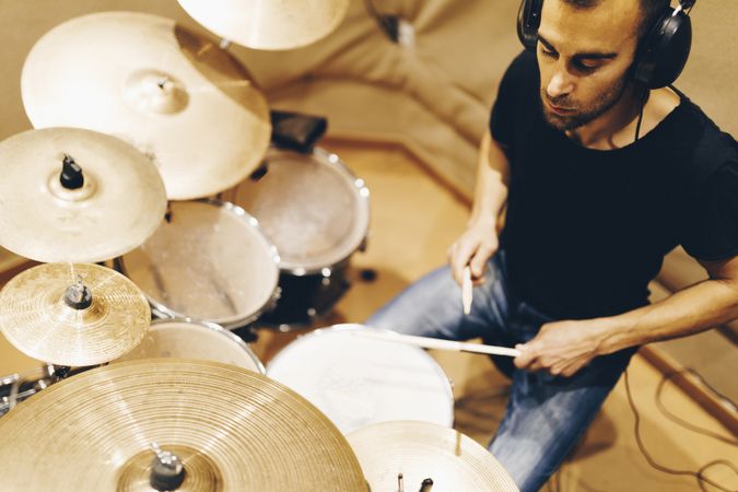 Man with headphones playing on drums