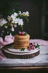 Pile of raspberry pancakes with honey on plate