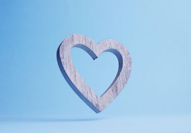 Wooden heart falling over blue background