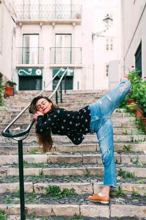 Casual woman dancing on old city street