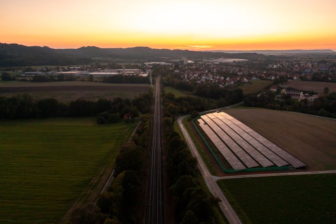 Railtracks and solar panels near a german village, drone aerial view