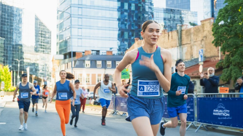 Diverse Group of People Running a Marathon in a City During the Day.