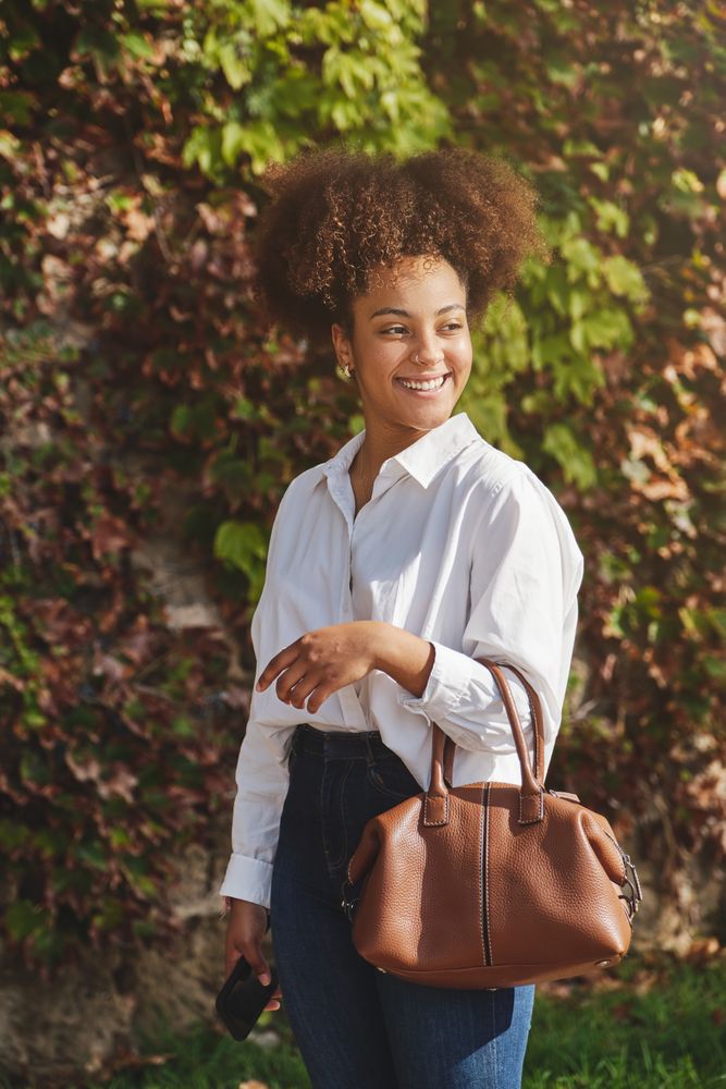 Young Black businesswoman in stylish outfit in park