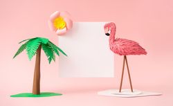 Palm tree and flamingo made of paper on pink background