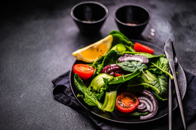 Spinach salad with cherry tomatoes and lemon slice
