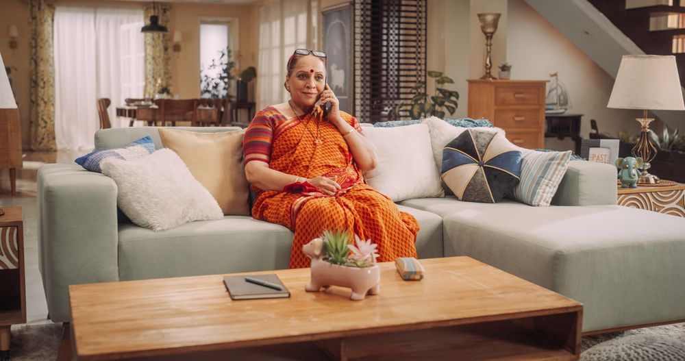 Mature Indian Woman Using Smartphone at Home: Talking with Loved Ones, Relatives, Friends, Grandchildren.